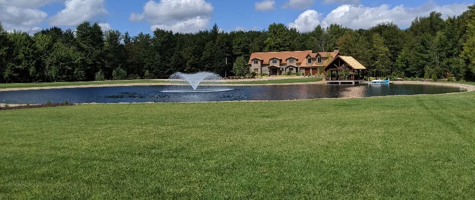 Healthy, green lawn in Mansfield, OH, near a lake and a house.