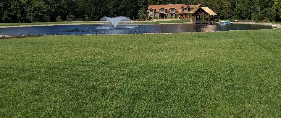 Large, green lawn in Mansfield, OH, with a fountain and house.