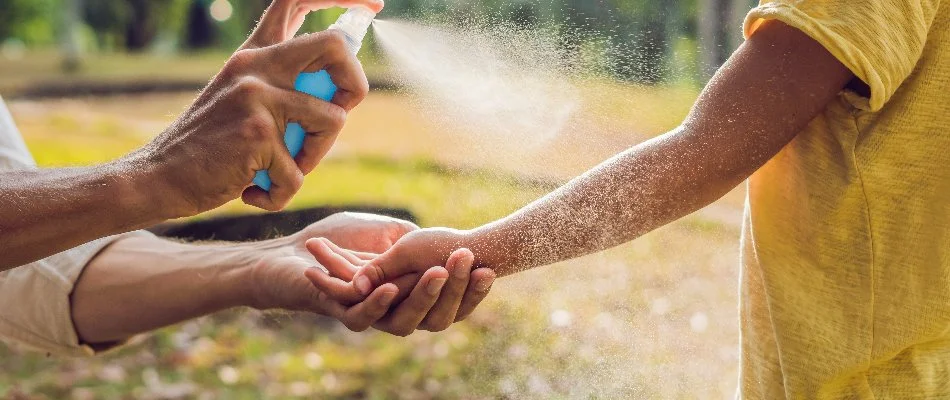 Person applying insect repellent on a child in Mansfield, OH.