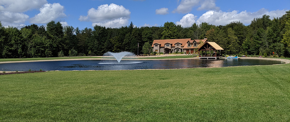 A beautiful lawn behind a home with a sprinkler in a pond in Independence, OH.