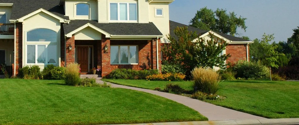 House in North Ridgeville, OH, with fertilized green grass and plants.