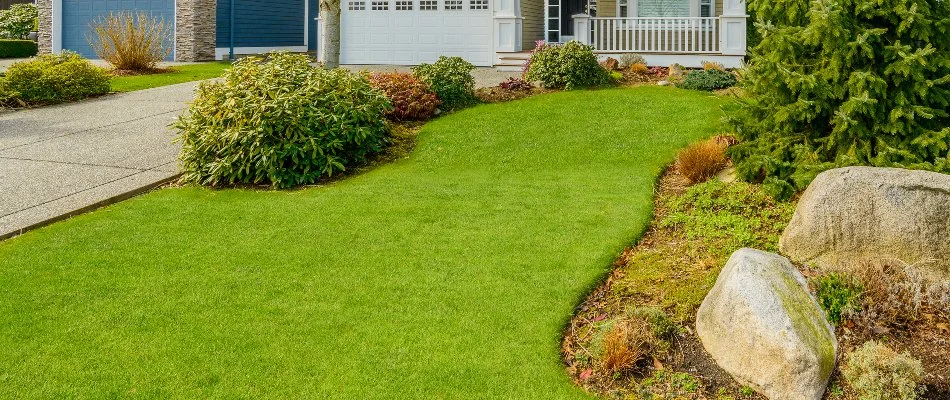 Lush green lawn with shrubs and rocks in Rittman, OH.